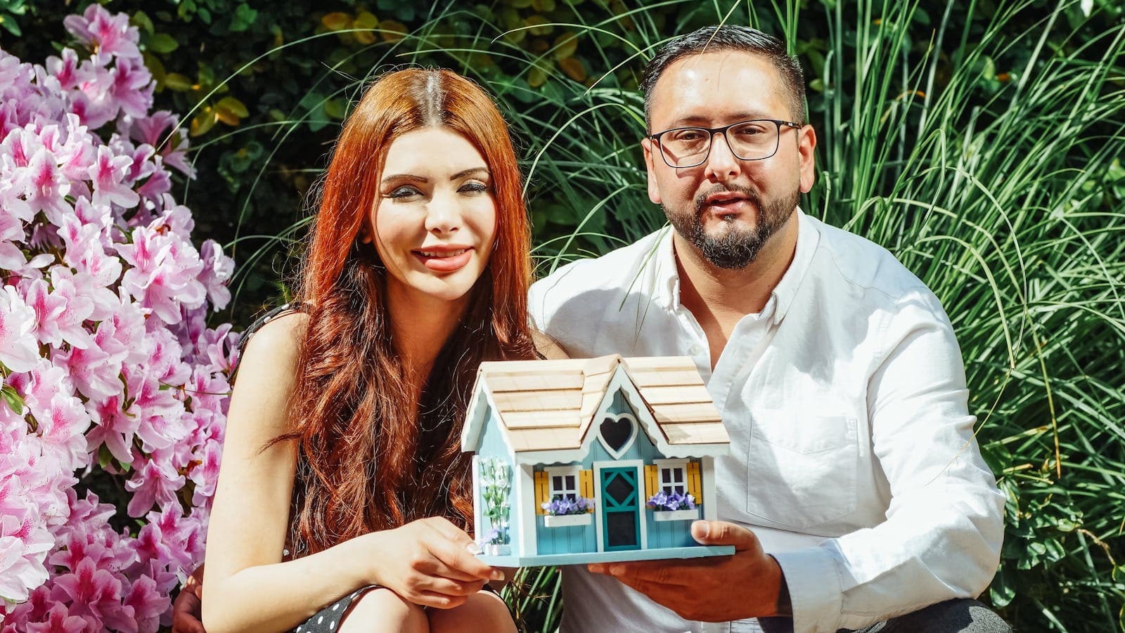 People holding a house model after a real estate conversation